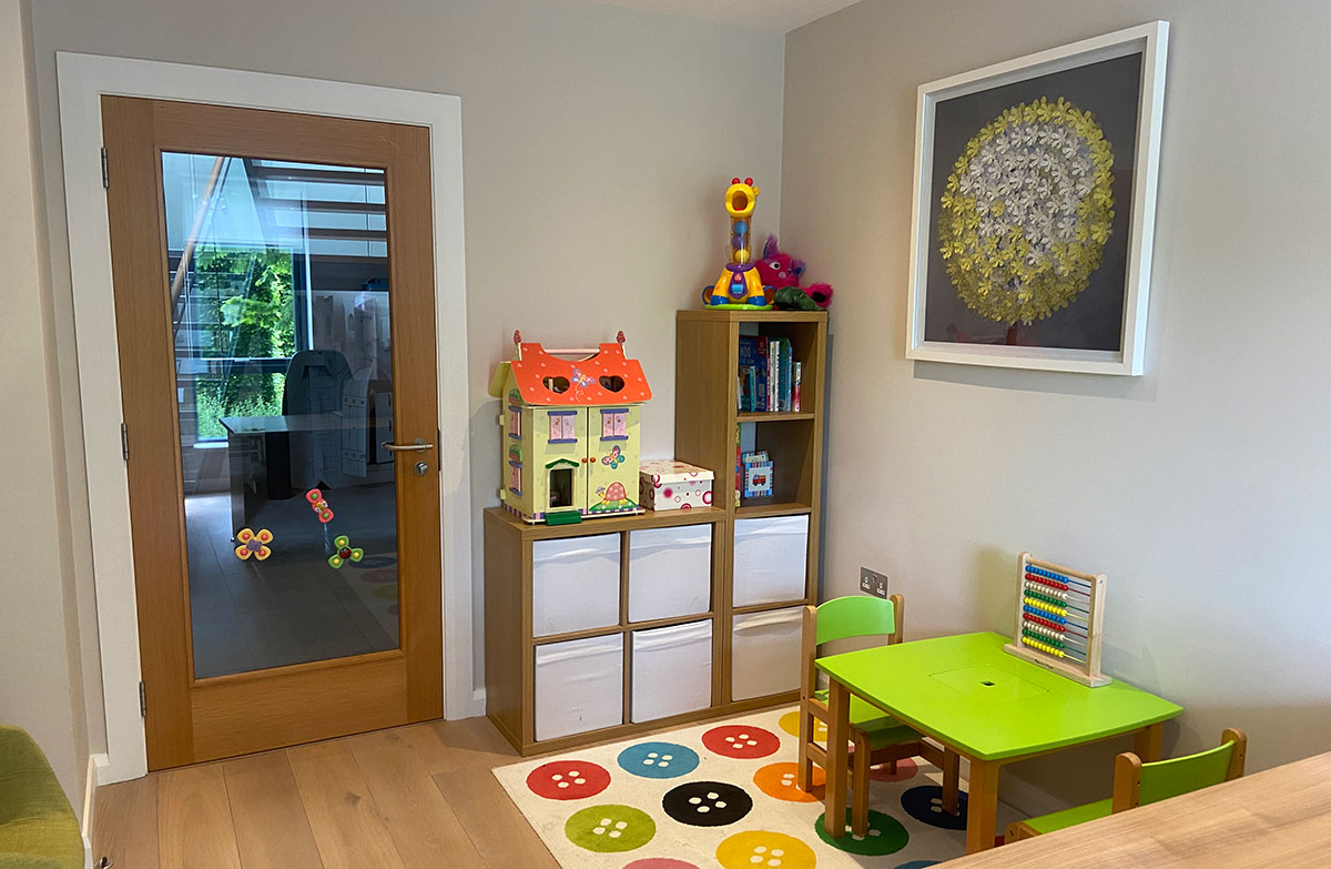 The children's therapy room at Tiny Talkers NI, with a play table, storage and toys